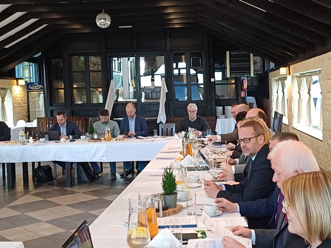 Zgromadzeni uczestnicy posiedzenia spotkali się w sali konferencyjnej. Zasiedli do stołu. Przyjęto porządek obrad